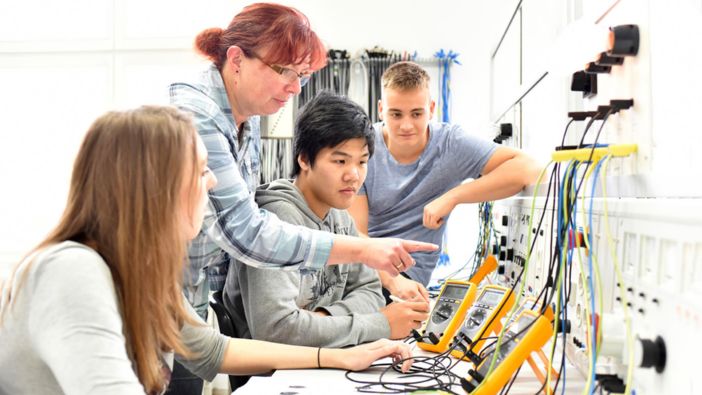 Eine Gruppe von jungen Menschen arbeitet gemeinsam an Elektronikprojekten in einem Ingenieurlabor. Eine Gruppe von jungen Menschen arbeitet gemeinsam an Elektronikprojekten in einem Ingenieurlabor.